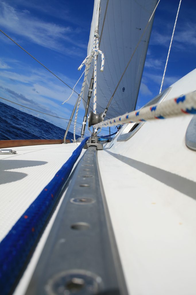 Velero navegando con cabos y aparejo en primer plano